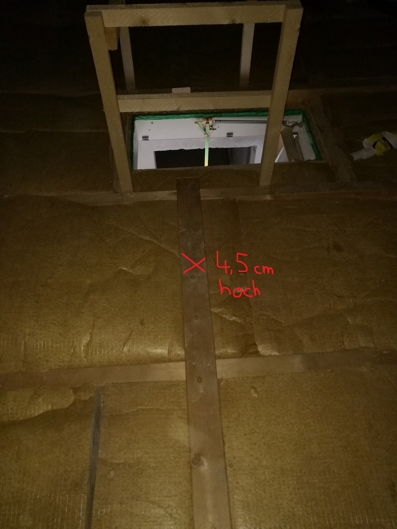 Dachboden mit Holzrahmen, Dämmung und Zugangsluke sichtbar