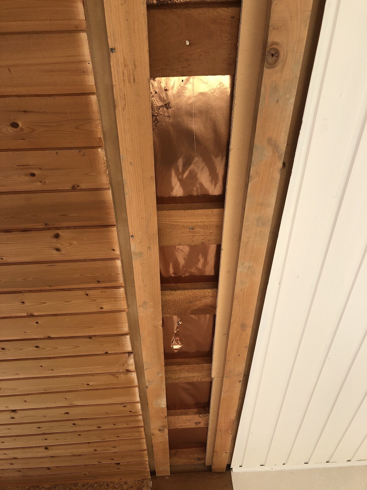 Offener Dachboden mit sichtbaren Holzbalken, Dämmfolie zwischen ihnen.