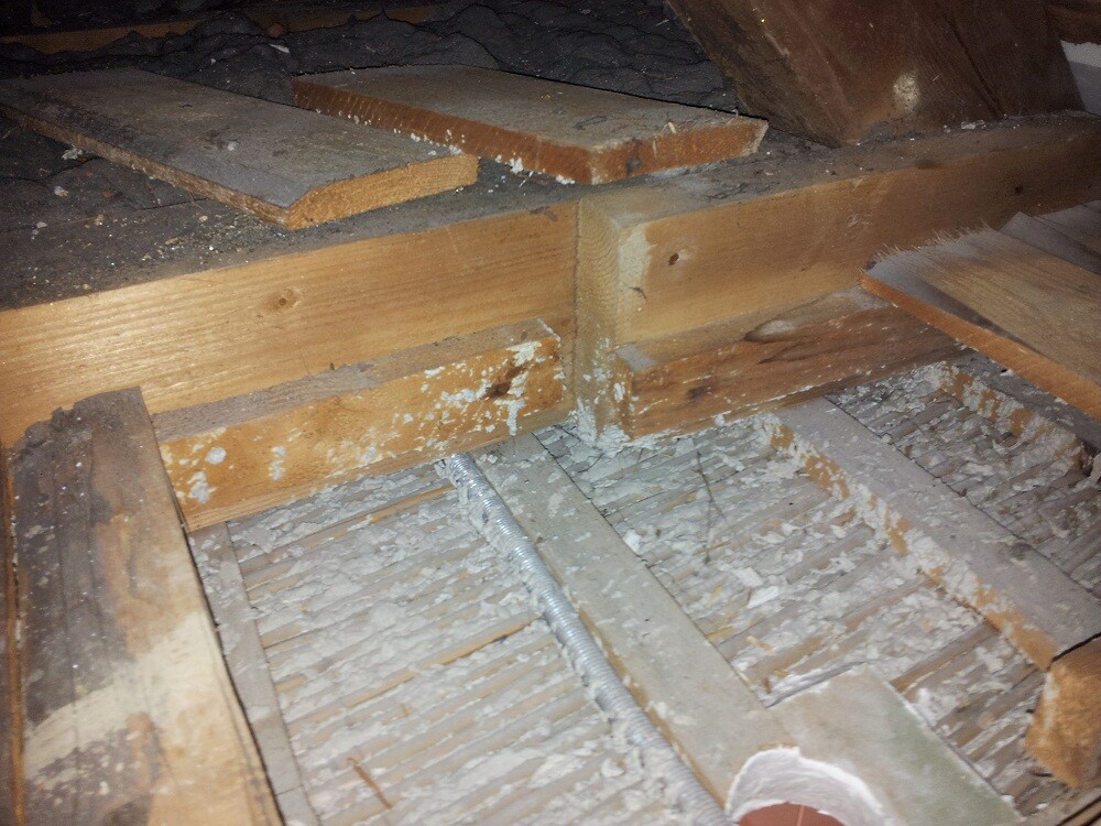 Dachboden mit Holzbalken, staubig, sichtbare Elektroleitung entlang der Holzstruktur