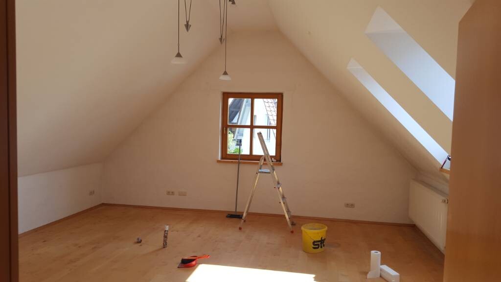 Dachgeschossraum während Renovierung mit Leiter, Fenster und Holzfußboden