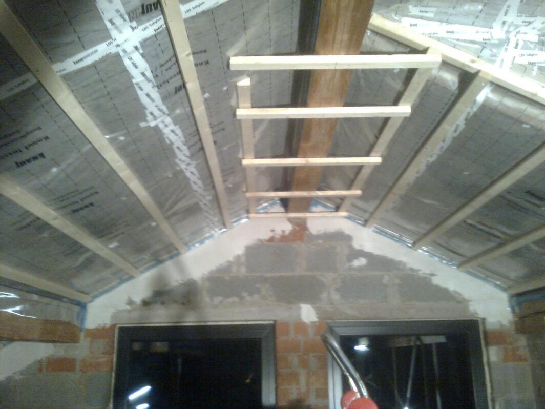 Holzleiter im Dachgeschoss, sichtbare Dämmung und Baufortschritt im Rohbau