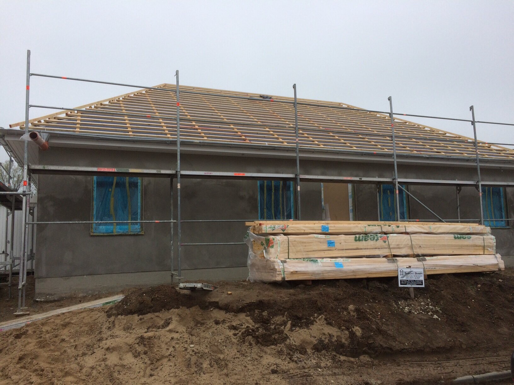 Baustelle mit Dachkonstruktion aus Holzrahmen, Gerüst um ein Haus