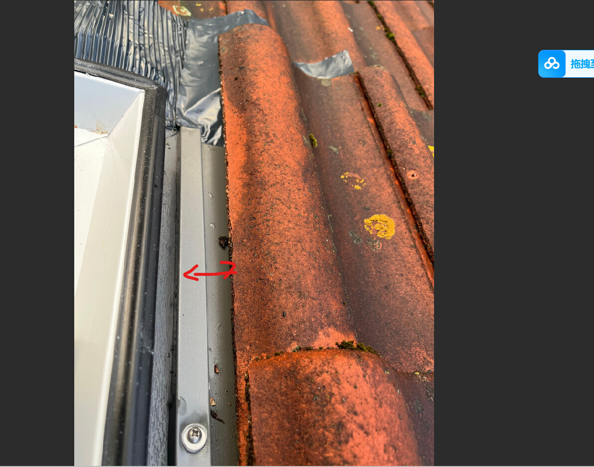 Nahaufnahme eines roten Dachziegels neben Fensterrahmen mit Blechrand