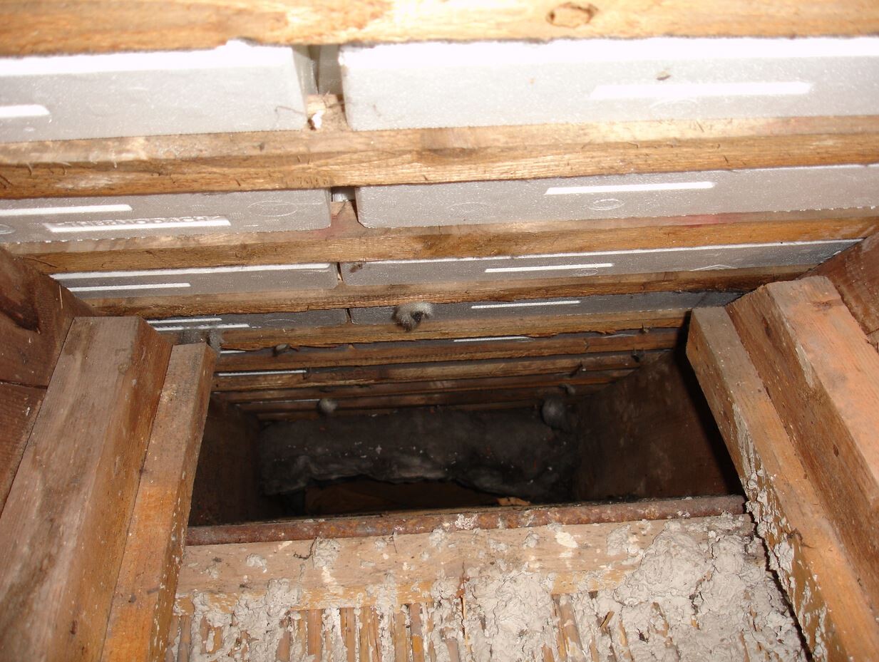 Dachboden mit Holzträgern und Dämmplatten zwischen den Balken