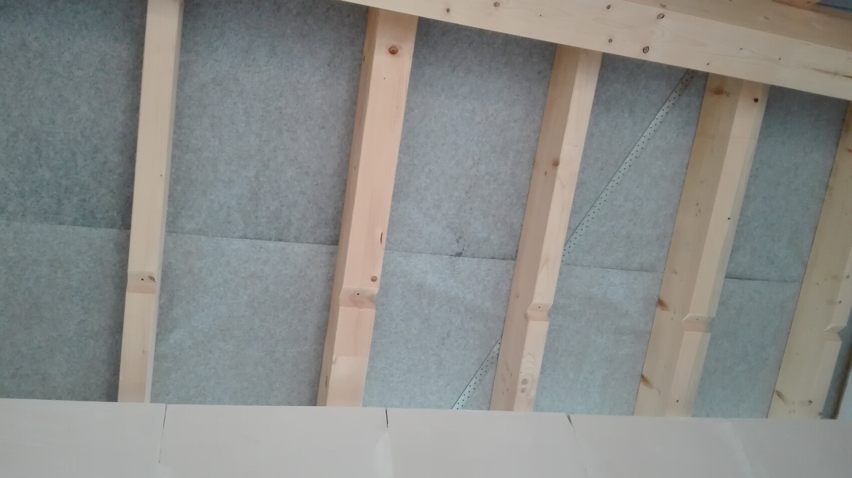 Holzstaenderwerk und blaues Daemmaterial zwischen Balken, Baufortschritt sichtbar