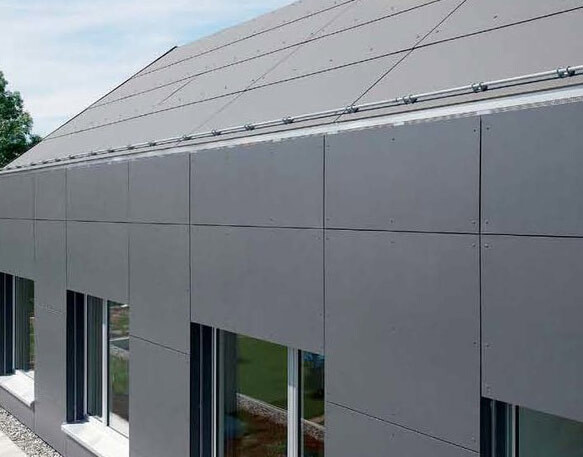 Moderne graue Fassadenverkleidung aus Paneelen mit Fenstern am Erdgeschoss und schrägem Dach.