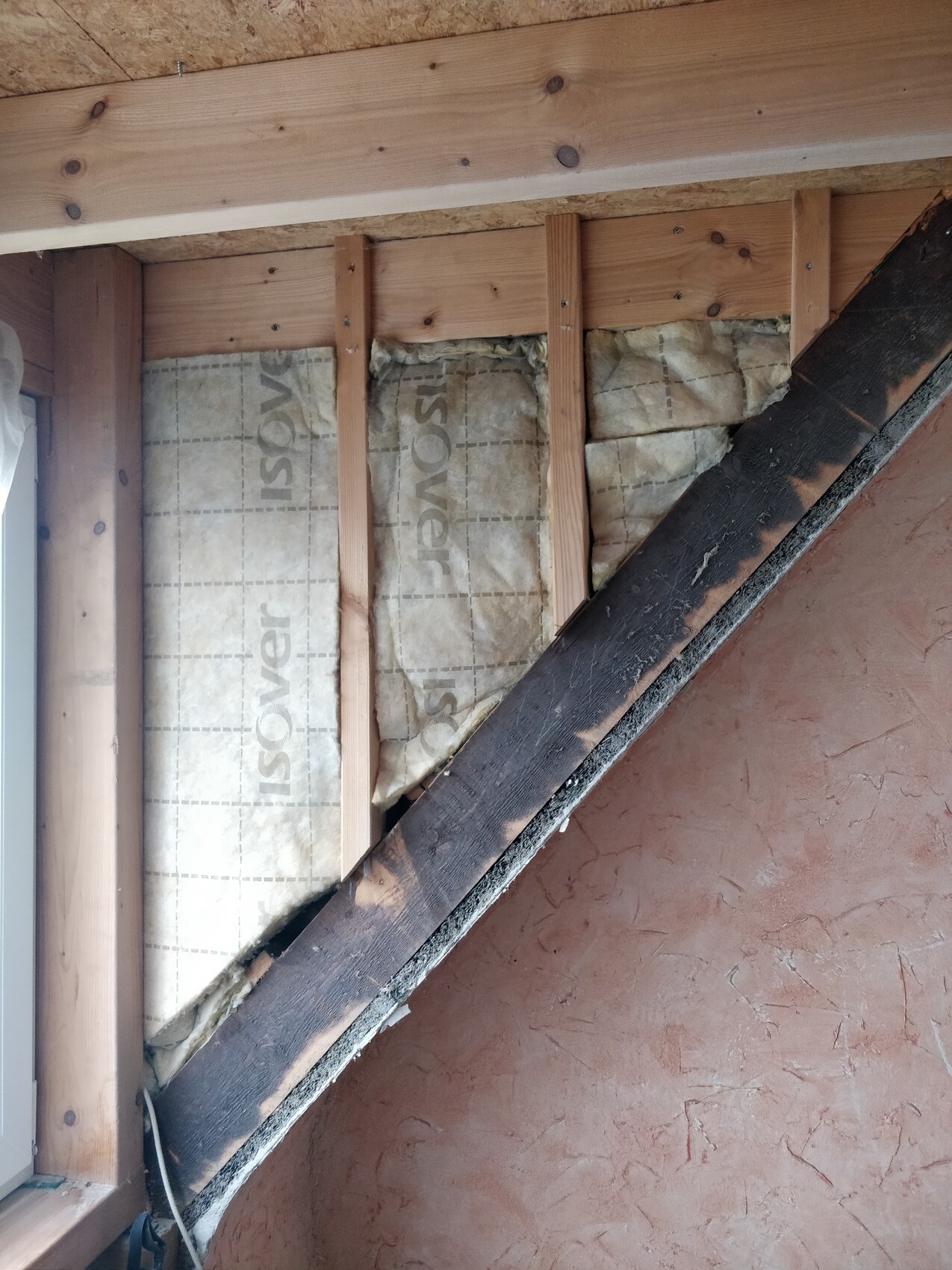 Dachboden-Wand mit Holzständern und Isover-Dämmung, diagonaler Holzbalken sichtbar