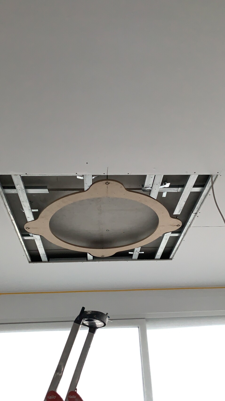 Offene Decke mit rundem Montagering; Leiter darunter, Installationsarbeiten an Beleuchtung.