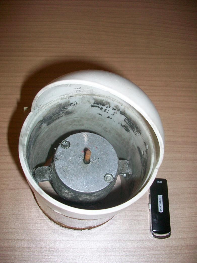 Weißer Deckenlampenkopf mit Metallmotor im Innenraum, liegt auf Holzoberfläche.