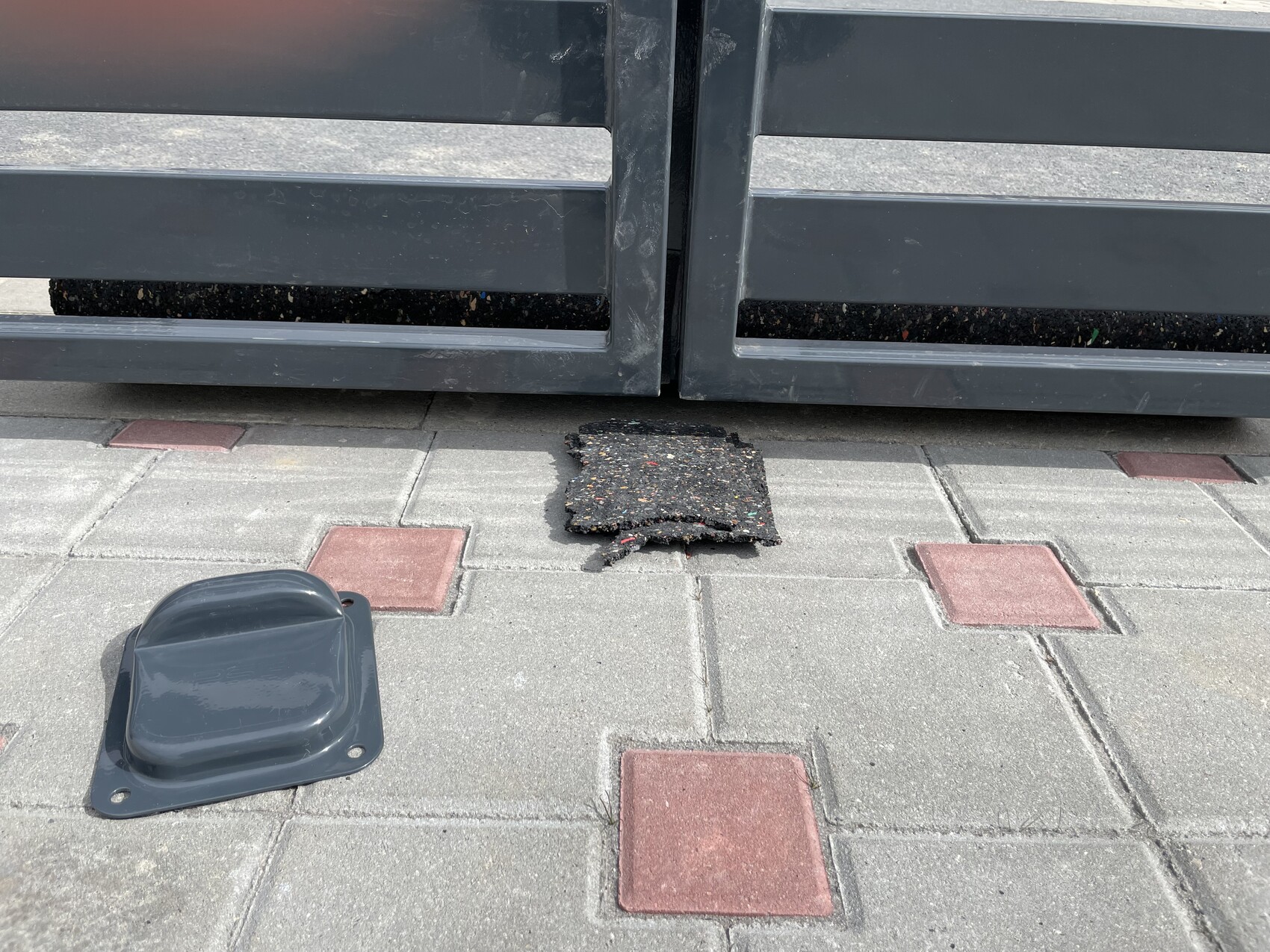 Grau Metalltor, beschädigte Pflasterplatte auf gepflastertem Vorplatz