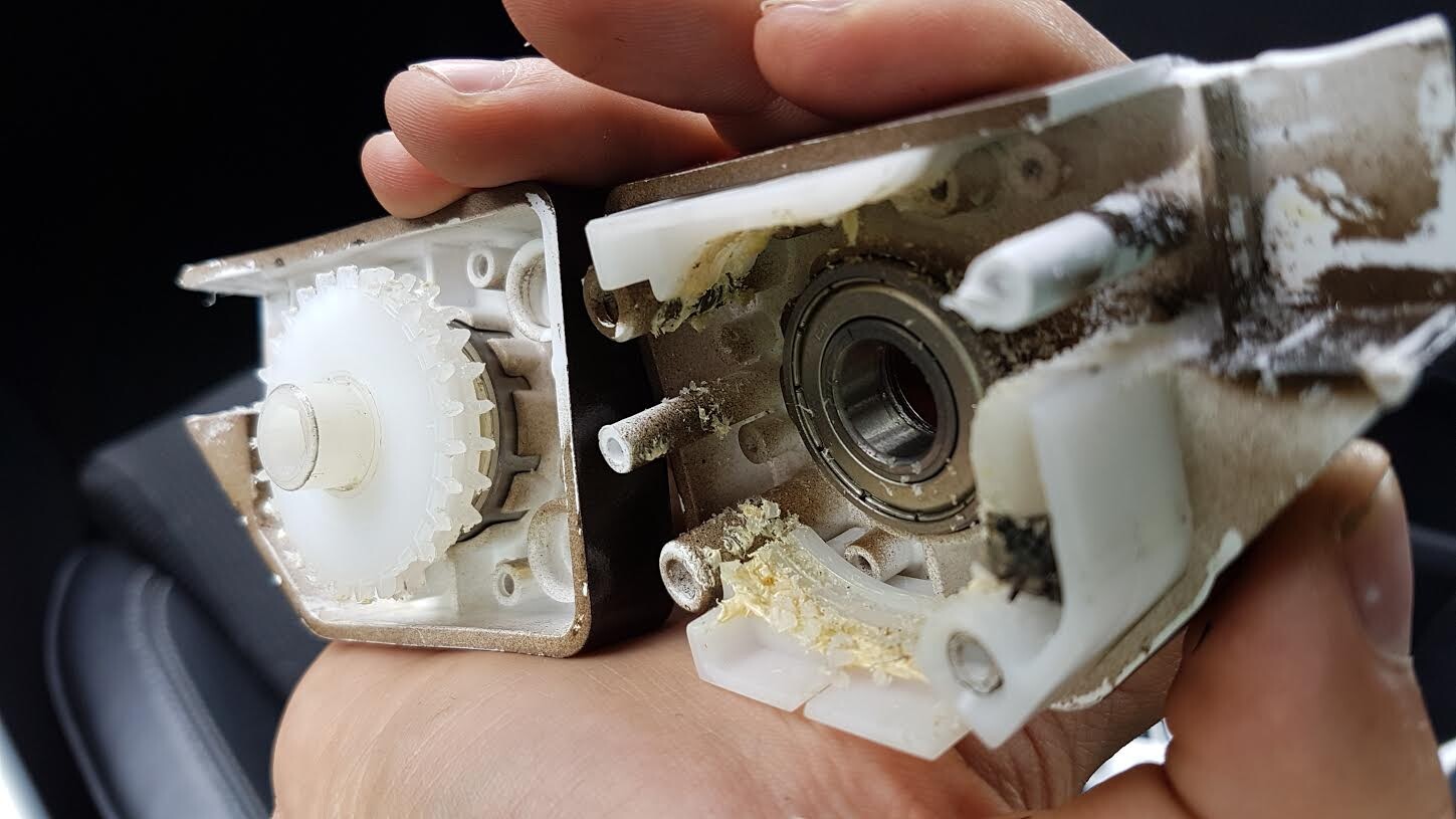 Nahaufnahme eines defekten Türbeschlags mit Zahnrädern und Lager im Innengehäuse.