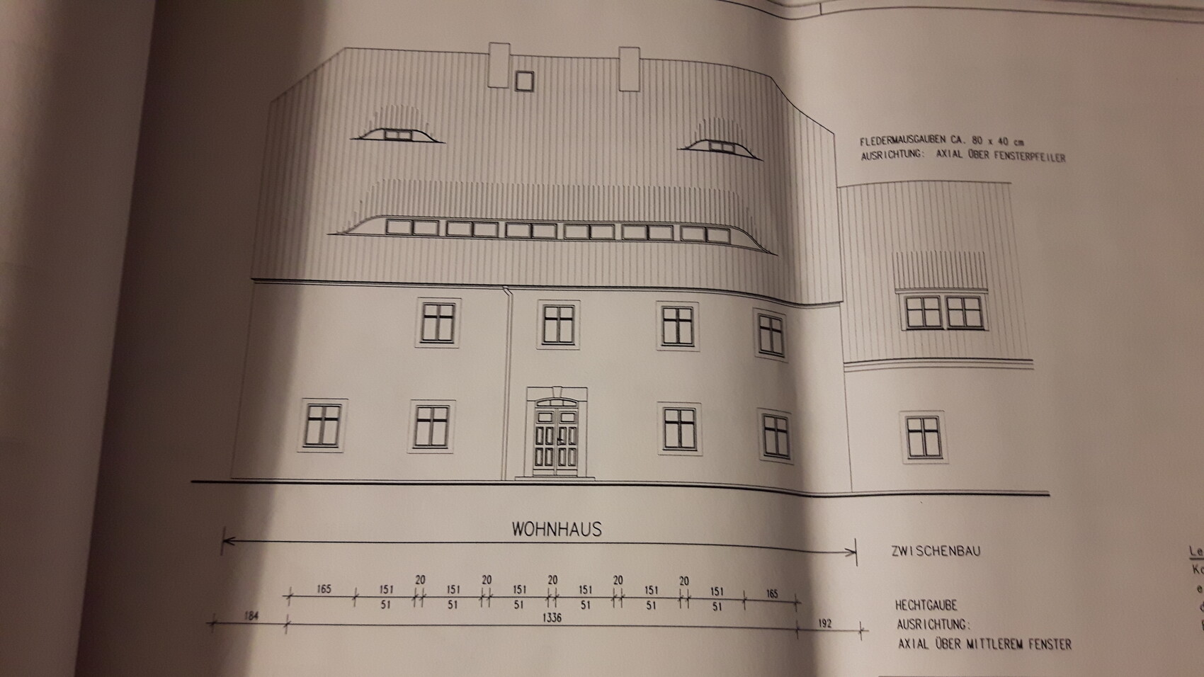 Architekturzeichnung eines mehrstöckigen Wohnhauses mit gebogenem Dach und zentraler Eingangstür