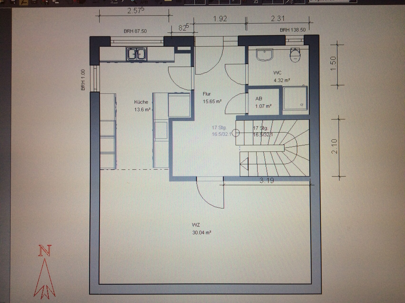 Grundriss eines Hauses: Küche links, Flur Mitte, Wohnzimmer rechts, WC und Abstellraum, Treppenhaus.