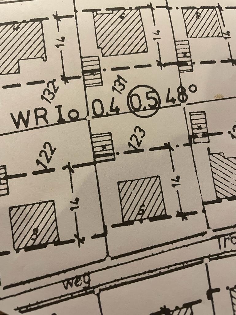 Architektur-Grundriss mit Maßlinien, Wänden und schraffierten Räumen.