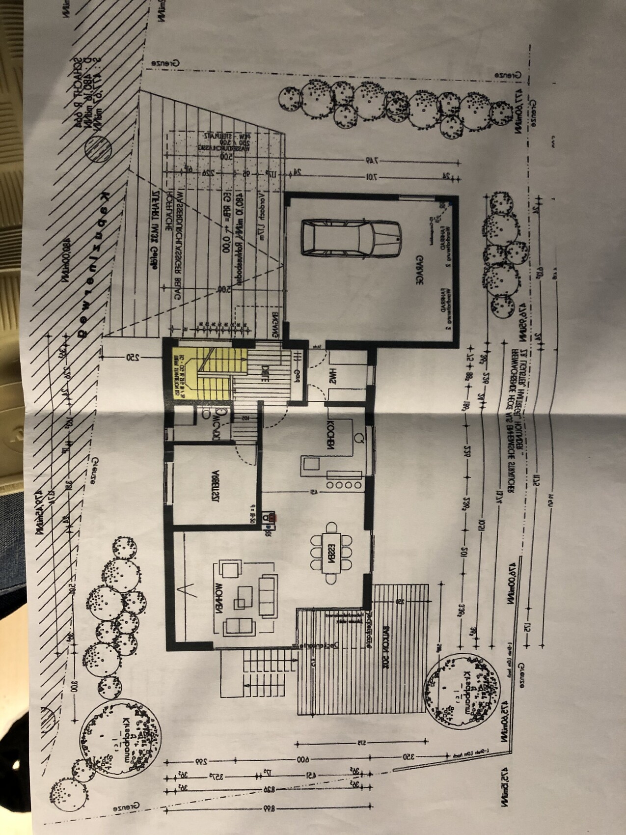 Grundriss eines Einfamilienhauses mit Garage, Eingangstreppe, offener Küche-Ess-Wohnbereich.