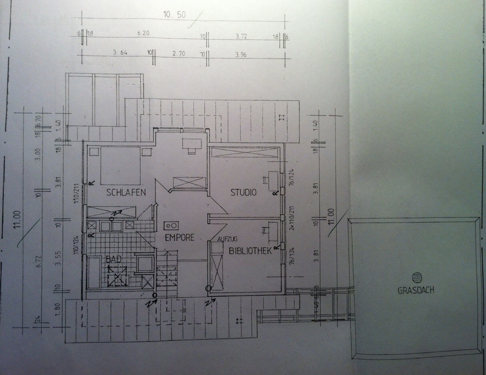 Grundriss eines Gebäudes mit Schlafzimmer, Studio, Empore, Bibliothek, Bad, Aufzug; Grasdach.