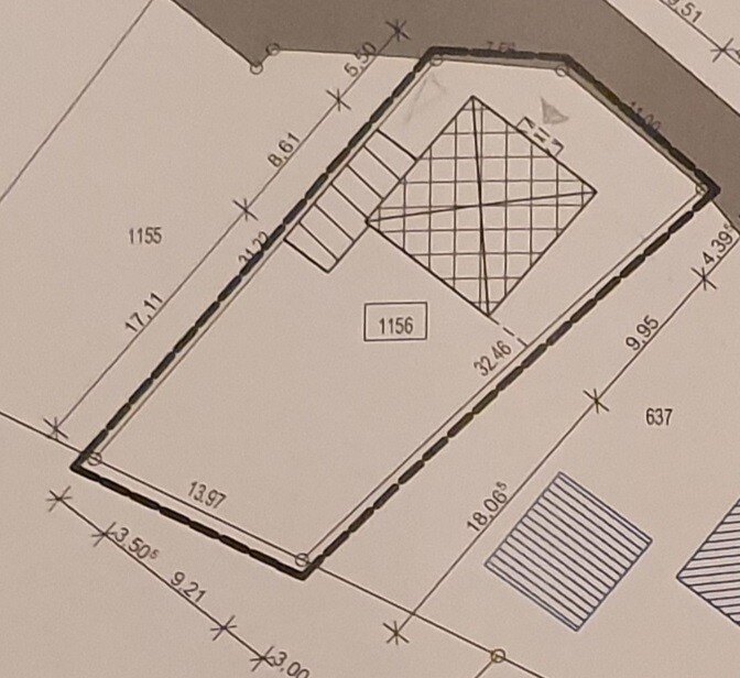 Lageplan eines unregelmäßigen Grundstücks mit Umfassung, Treppe links und schraffiertem Innenbau.