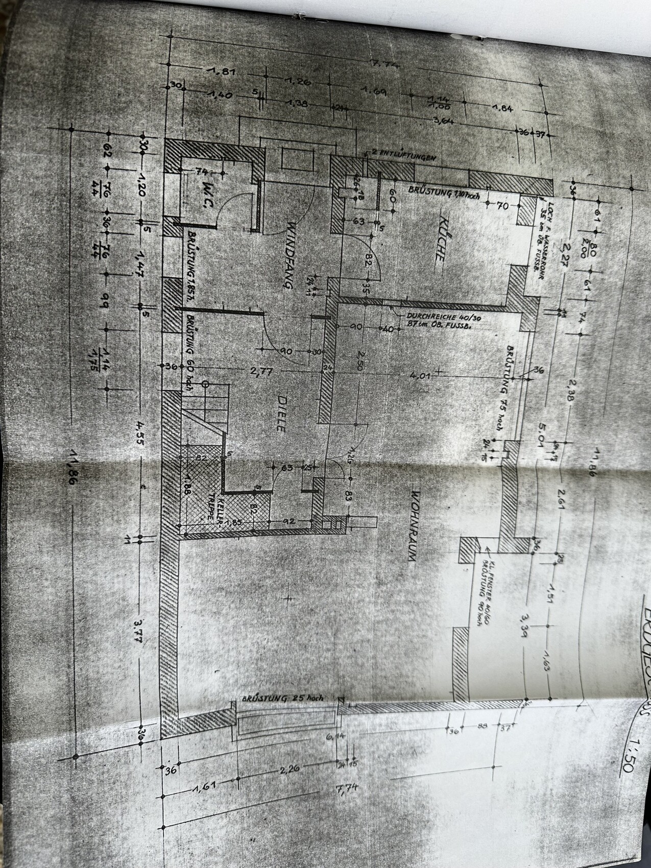 Grundriss eines Wohnhauses mit Küche, WC, Türen und Maßangaben.