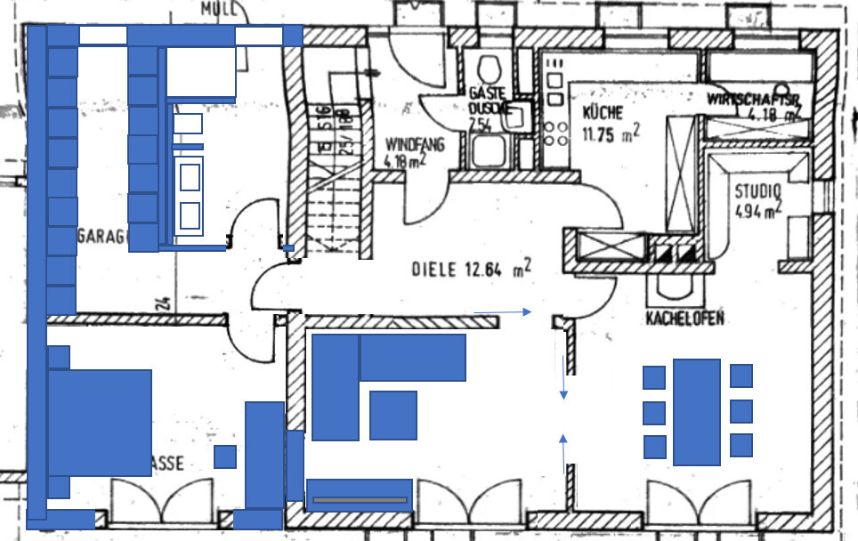 Grundriss eines Hauses mit blauer Markierung: Garage, Diele, Küche, Studio, Kachelofen.