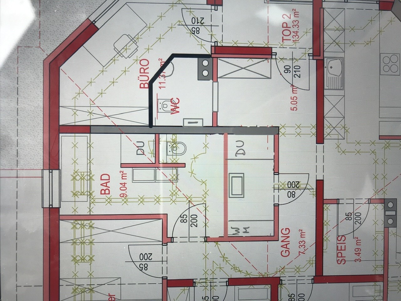 Grundriss einer Wohnung mit Bad, Büro, Gang, Speis und Küche; Wände und Türen sichtbar.