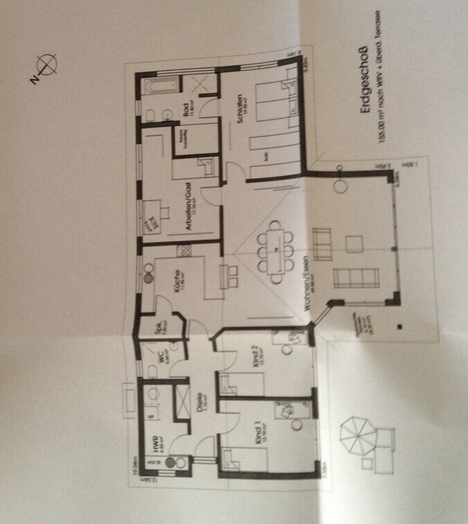 2D-Hausgrundrissplan mit Wohnzimmer, Küche, Bad und Fluren, Orientierungskreis auf der linken Seite.
