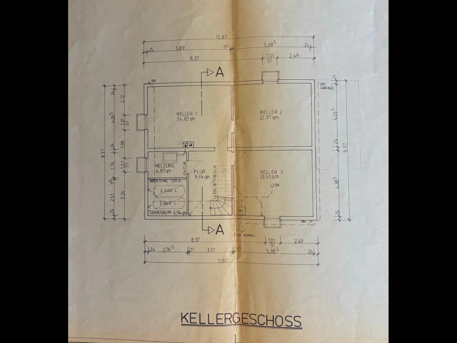 Grundriss Kellergeschoss: drei Kellerräume, Heizungs- und Tankraum, Flur.