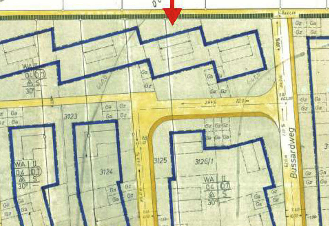 Lageplan einer Siedlung mit blauen Grundstücksgrenzen und gelben Straßen; roter Pfeil oben.