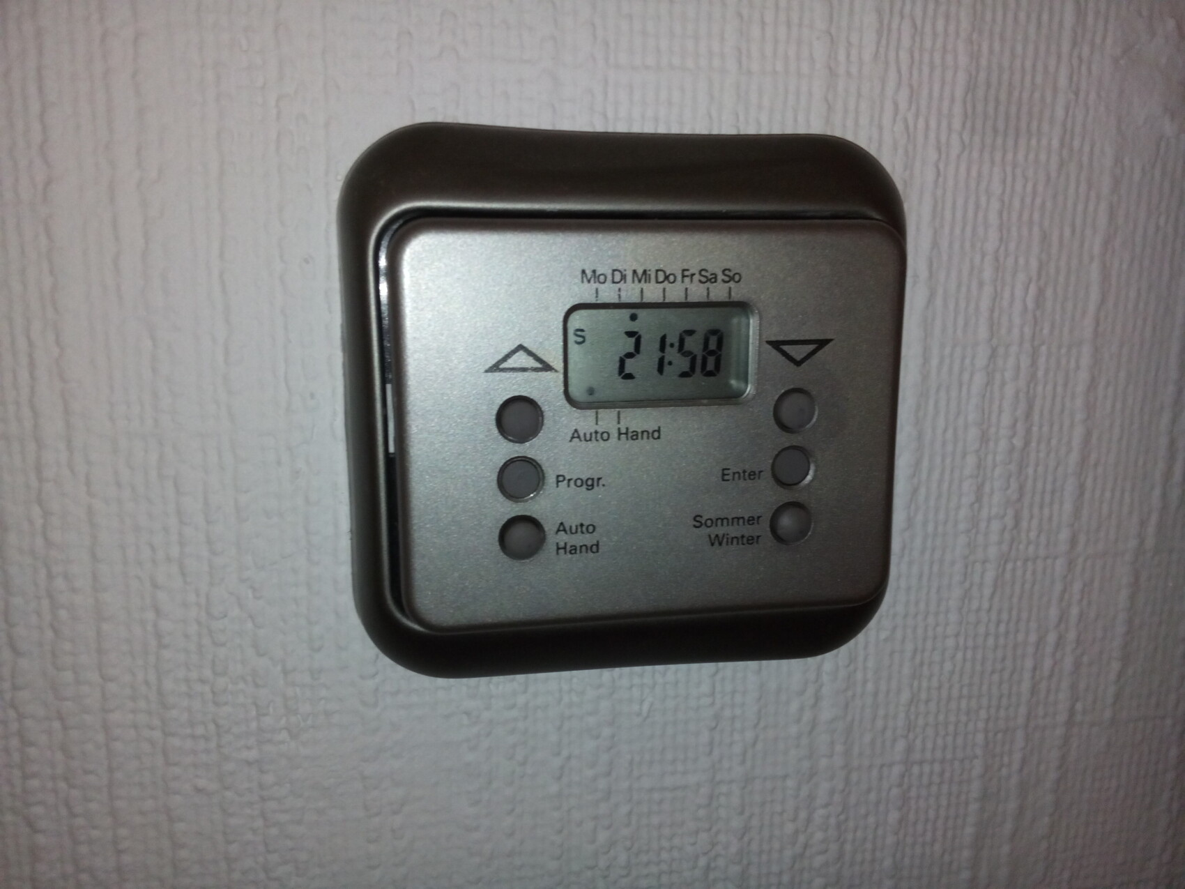 Digitale Wandthermostat mit Display und Tasten an heller Wand