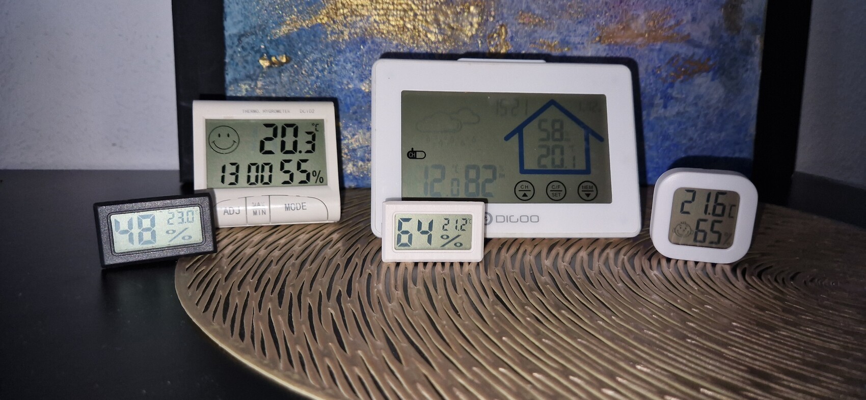 Mehrere digitale Raumklima-Sensoren zeigen Temperatur und Luftfeuchte auf einer Platte.