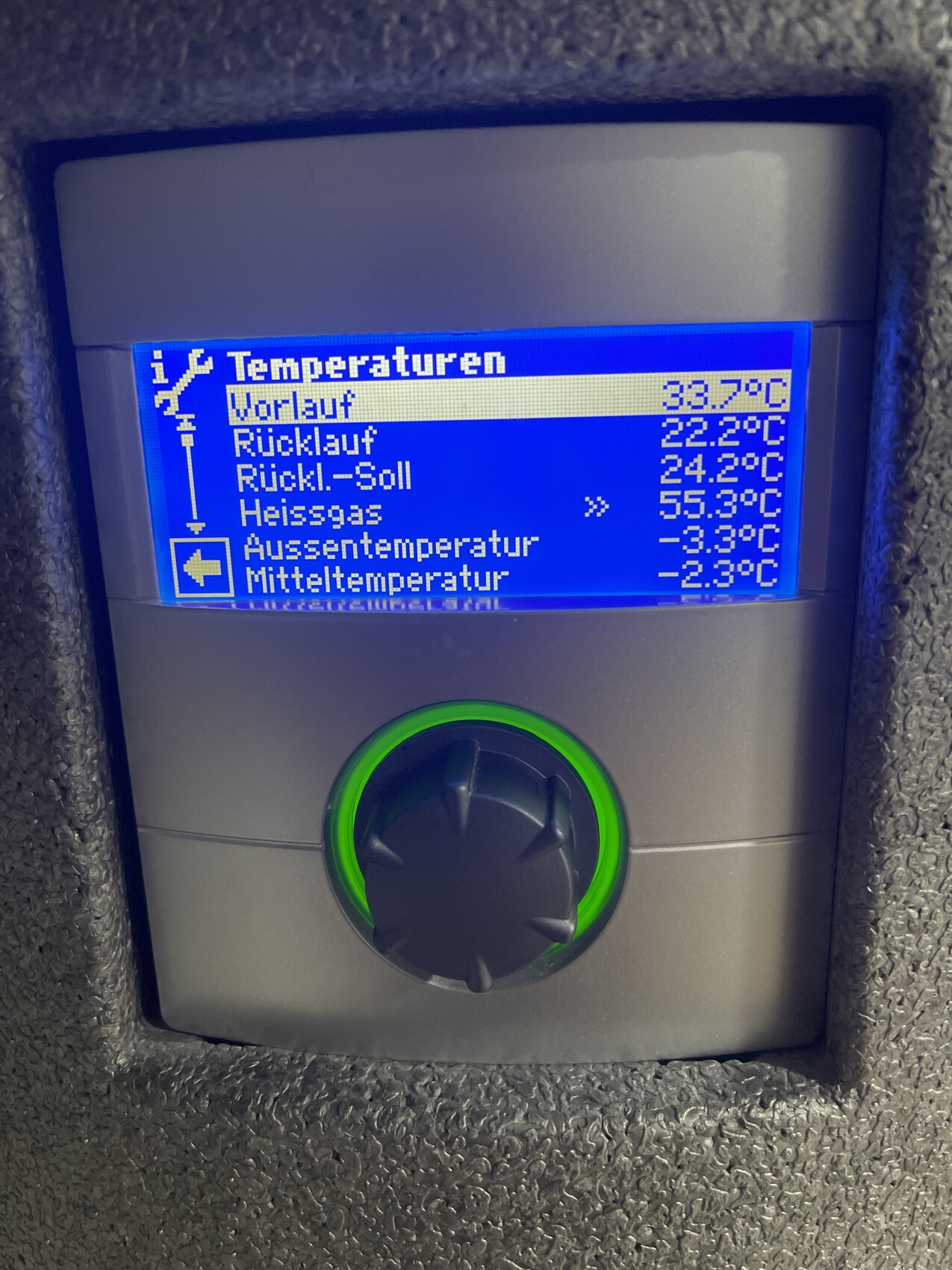 Bedienpanel mit blauem Display: Vorlauf 33.7°C, Rücklauf 22.2°C, Drehknopf.