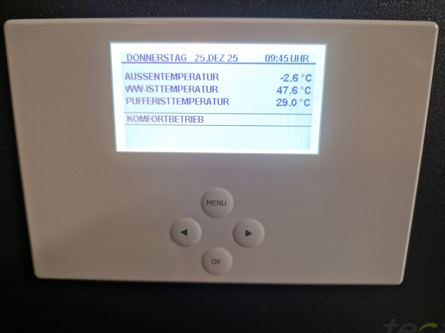 Wandthermostat mit Display zeigt Außentemperatur, Innentemperatur und Systemwerte