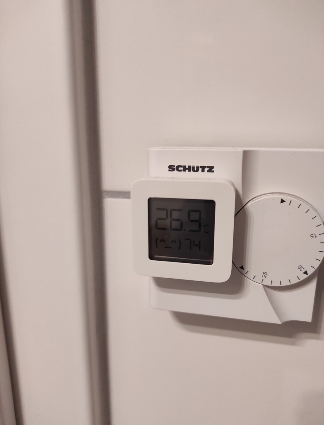 Digitaler Wandthermostat mit Display und Drehknopf an der Heizungssteuerung.