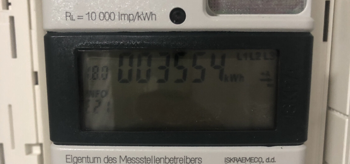 Digitaler Stromzähler mit Kilowattstundenanzeige in schwarz-weißem Gehäuse.