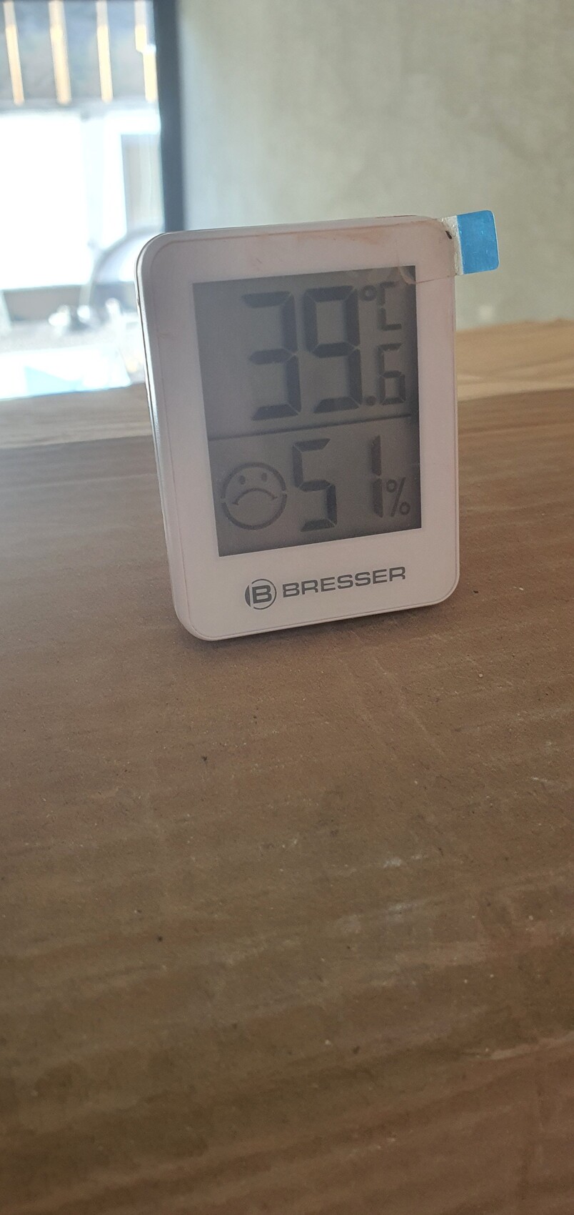 Kleines Thermometer-Hygrometer auf Holz zeigt 39°C und 51% Luftfeuchtigkeit