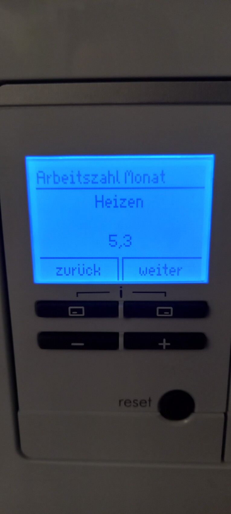 Digitales Display eines Heizungssteuergeräts: Arbeitszahl Monat, Heizen, 5,3; Zurück/Weiter.