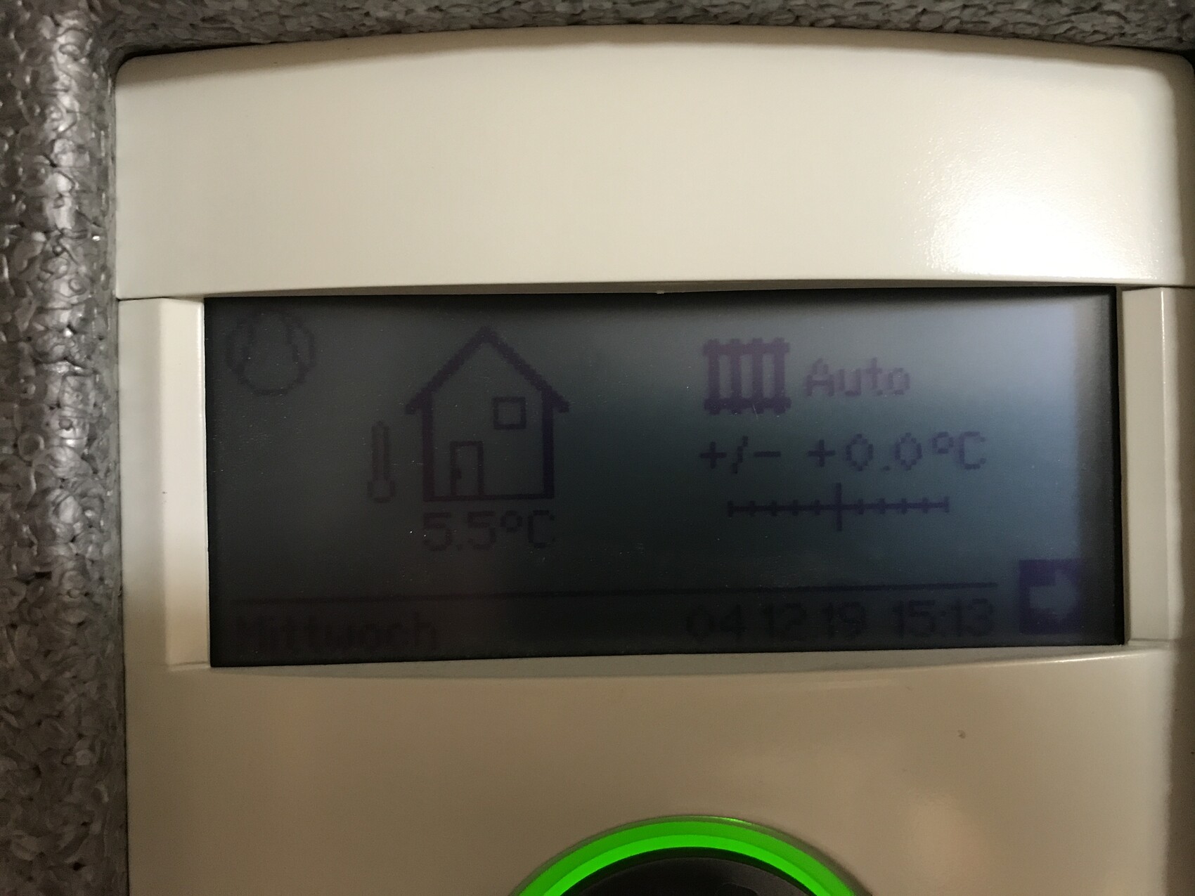 Digitales Thermostat-Display mit Haus-Symbol, Auto-Modus, Anzeige 5.9°C, gruenem Knopf.