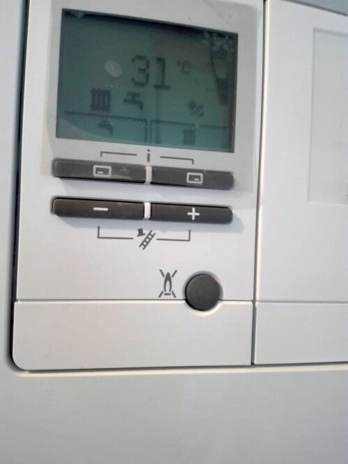 Thermostat-Display eines Klimageräts zeigt 31°C, Plus/Minus-Tasten und Symbole.
