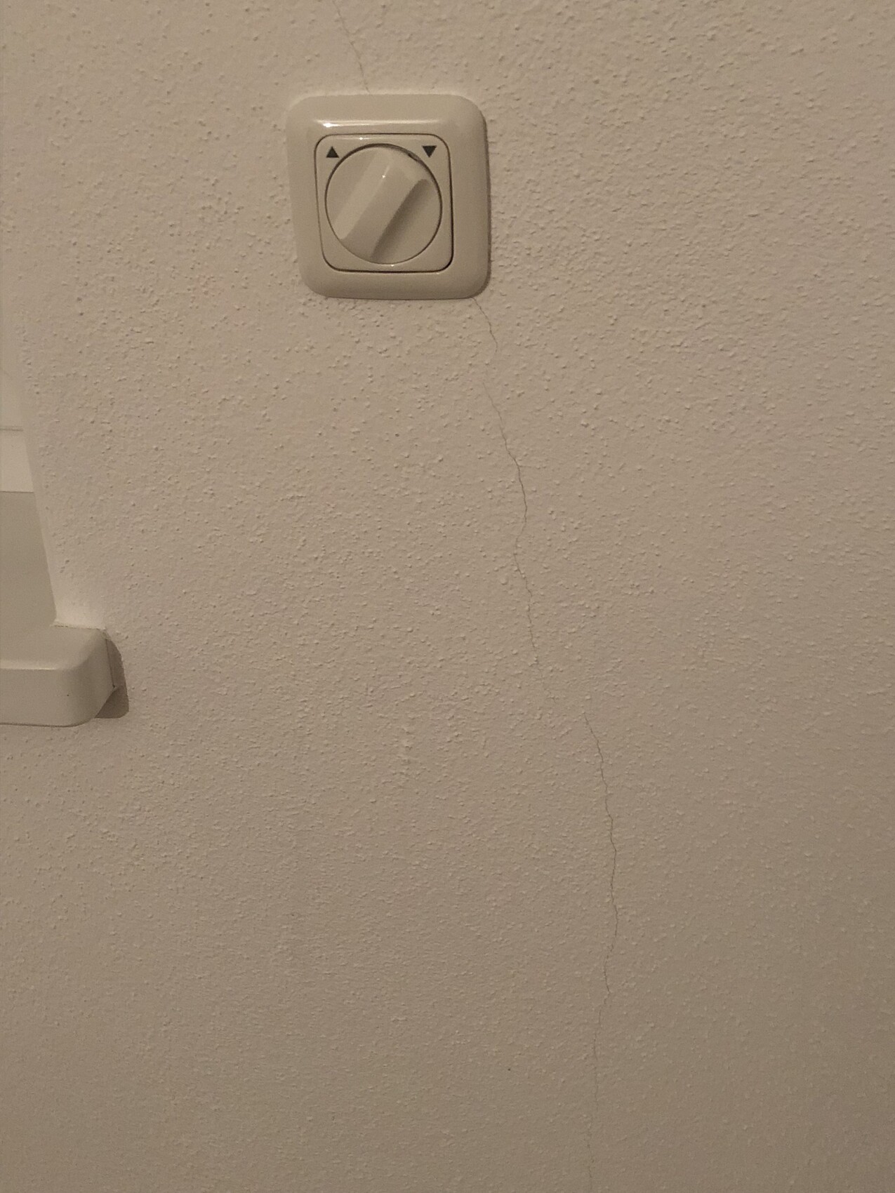 Weisser-wand-dimmer-lichtschalter-mit-riss