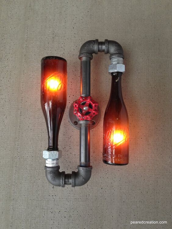 Upcycling-Lampe: zwei Glasflaschen als Leuchten, rotes Glühlicht, Rohr-Ventil-Verbindung.