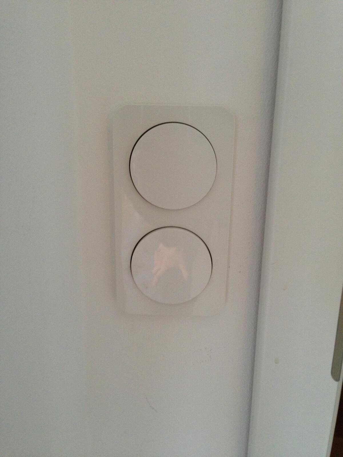 Zwei runde weiße Wandschalter-Dimmer an einer hellen Wand