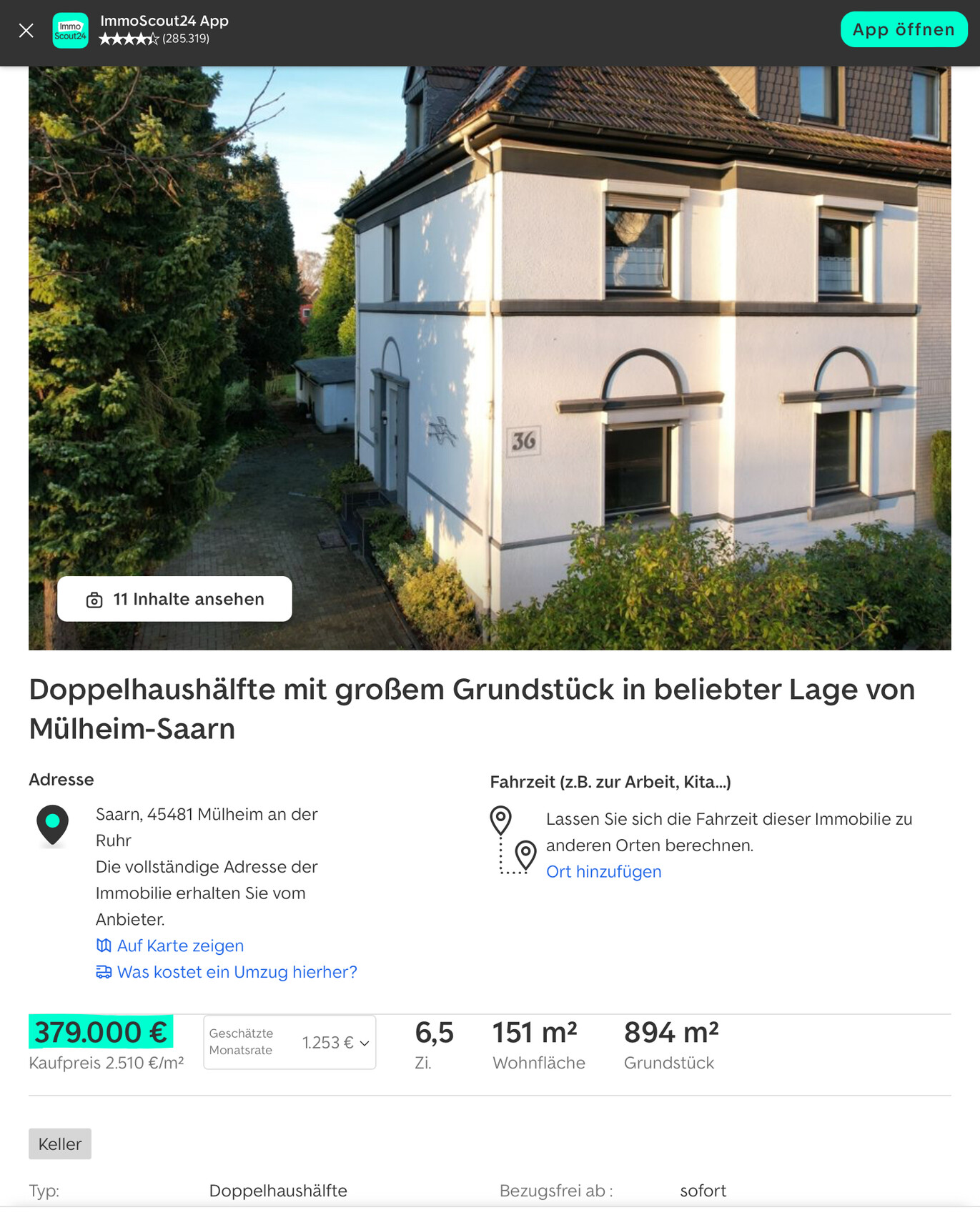 Außenansicht einer weißen Doppelhaushälfte mit grauen Zierbögen und Garten