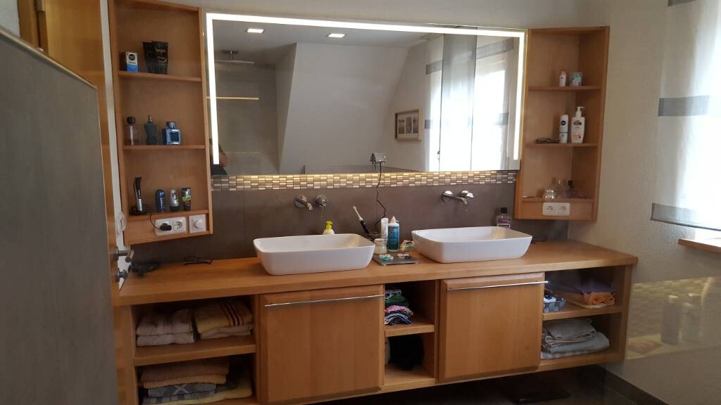 Doppelwaschbecken aus Keramik auf Holzunterbau mit Spiegel und Ablage im Badezimmer