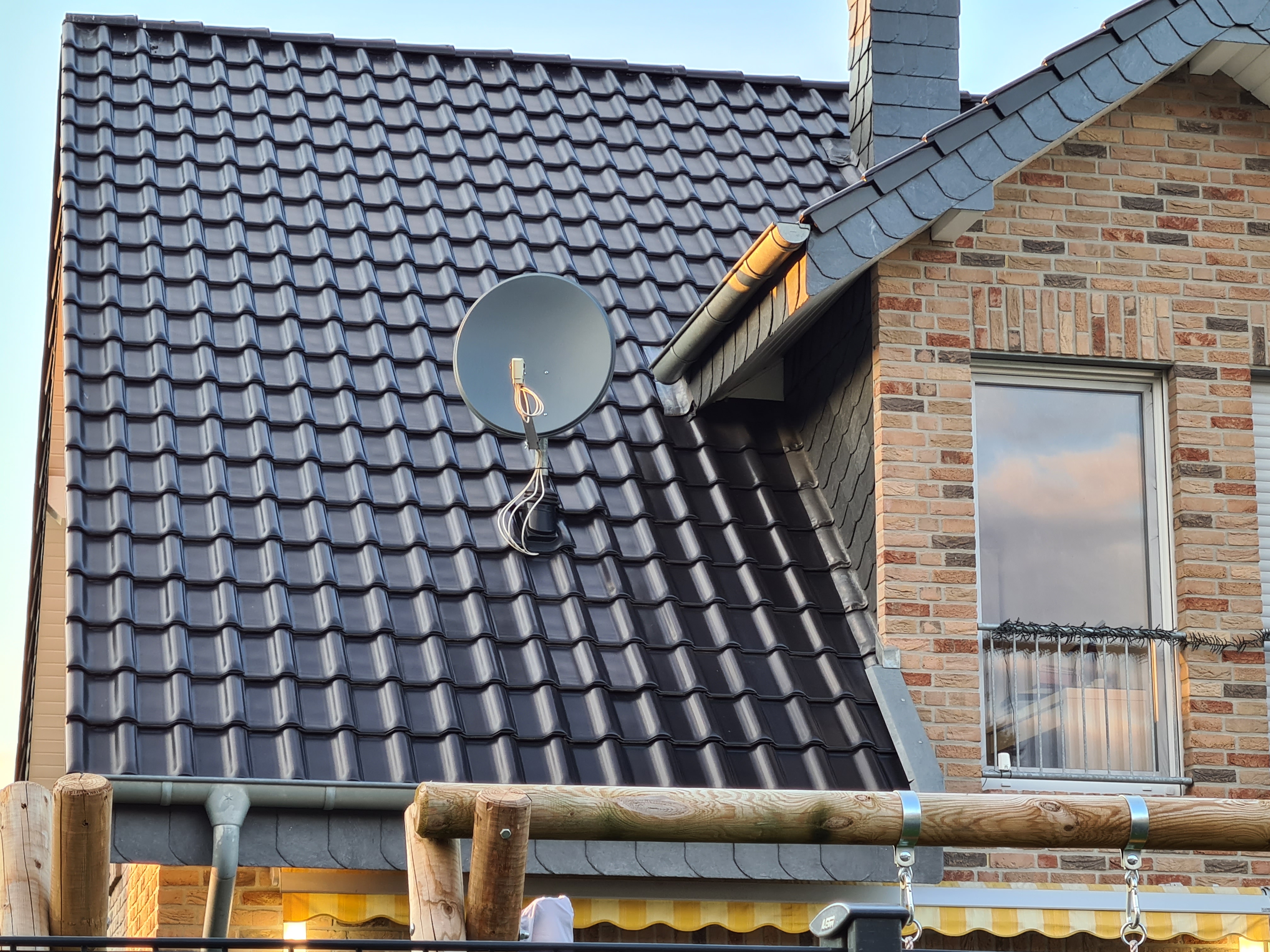 dunkelgraue-dachziegel-dach-auf-wohnhaus-mit-satellitenschuessel.jpg