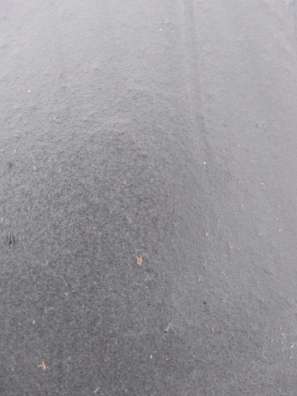 Dunkler Asphaltboden mit kleinen Kieseln, Außenbereich