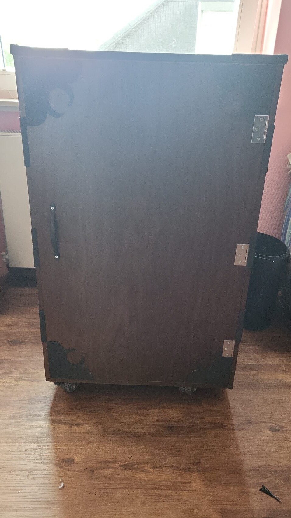 dunkler-holzschrank-auf-rollen-im-zimmer.jpeg