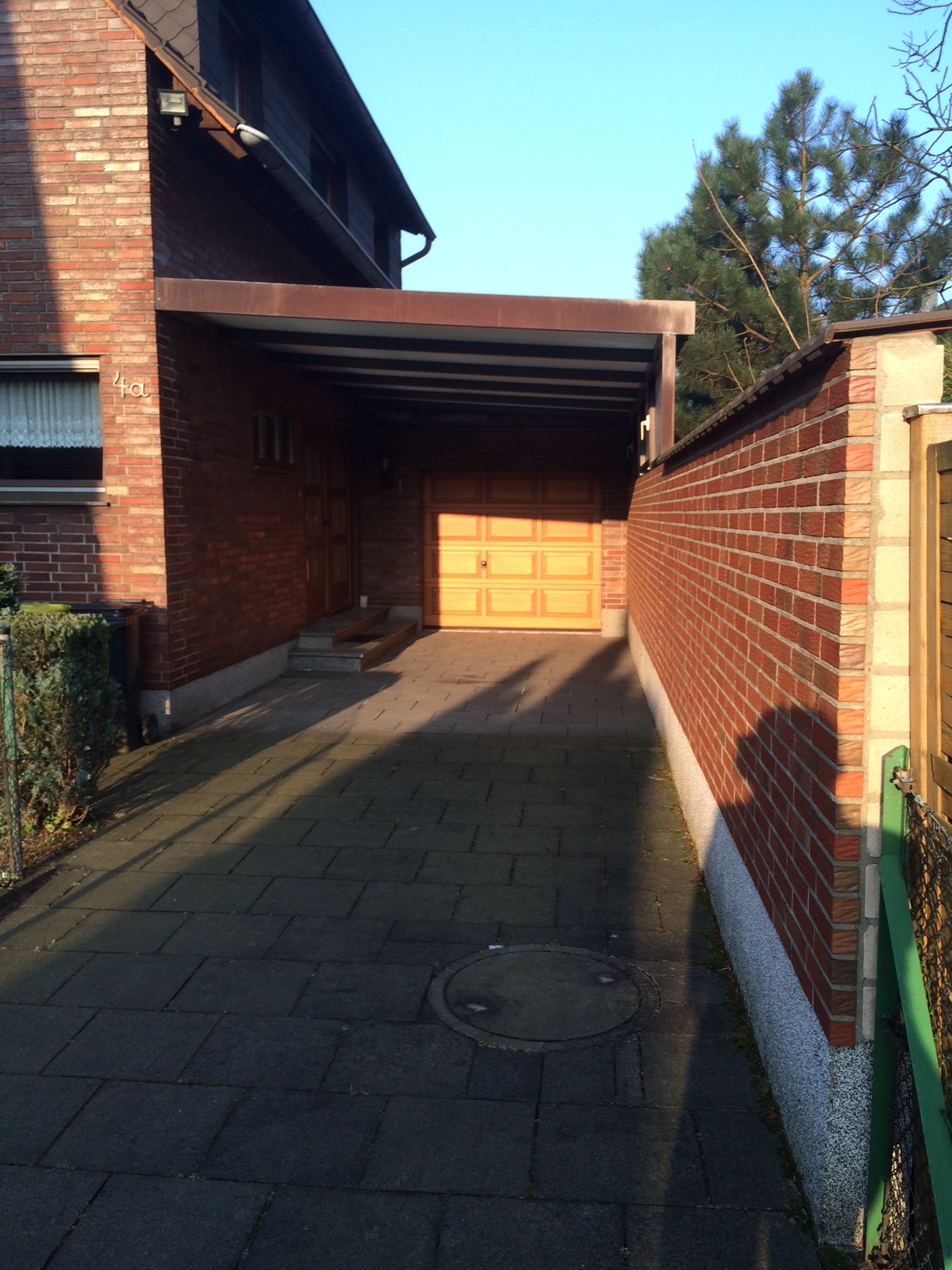 einfahrt-zu-einfamilienhaus-mit-garage-carport-und-ziegelwaenden.JPG
