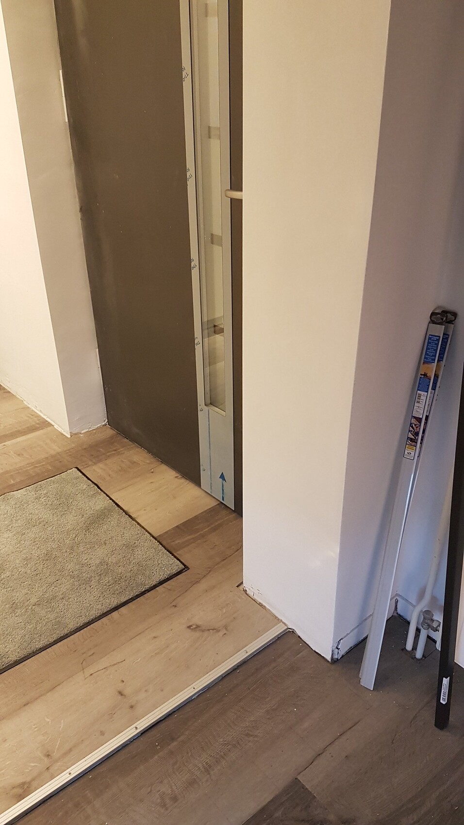 Eingangsbereich mit Aufzugtür, Holzboden und Werkzeugleiste daneben.