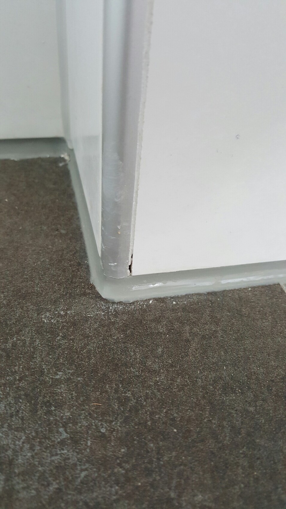 Weißer Türrahmen mit grauer Sockelleiste am dunklen Boden im Innenraum