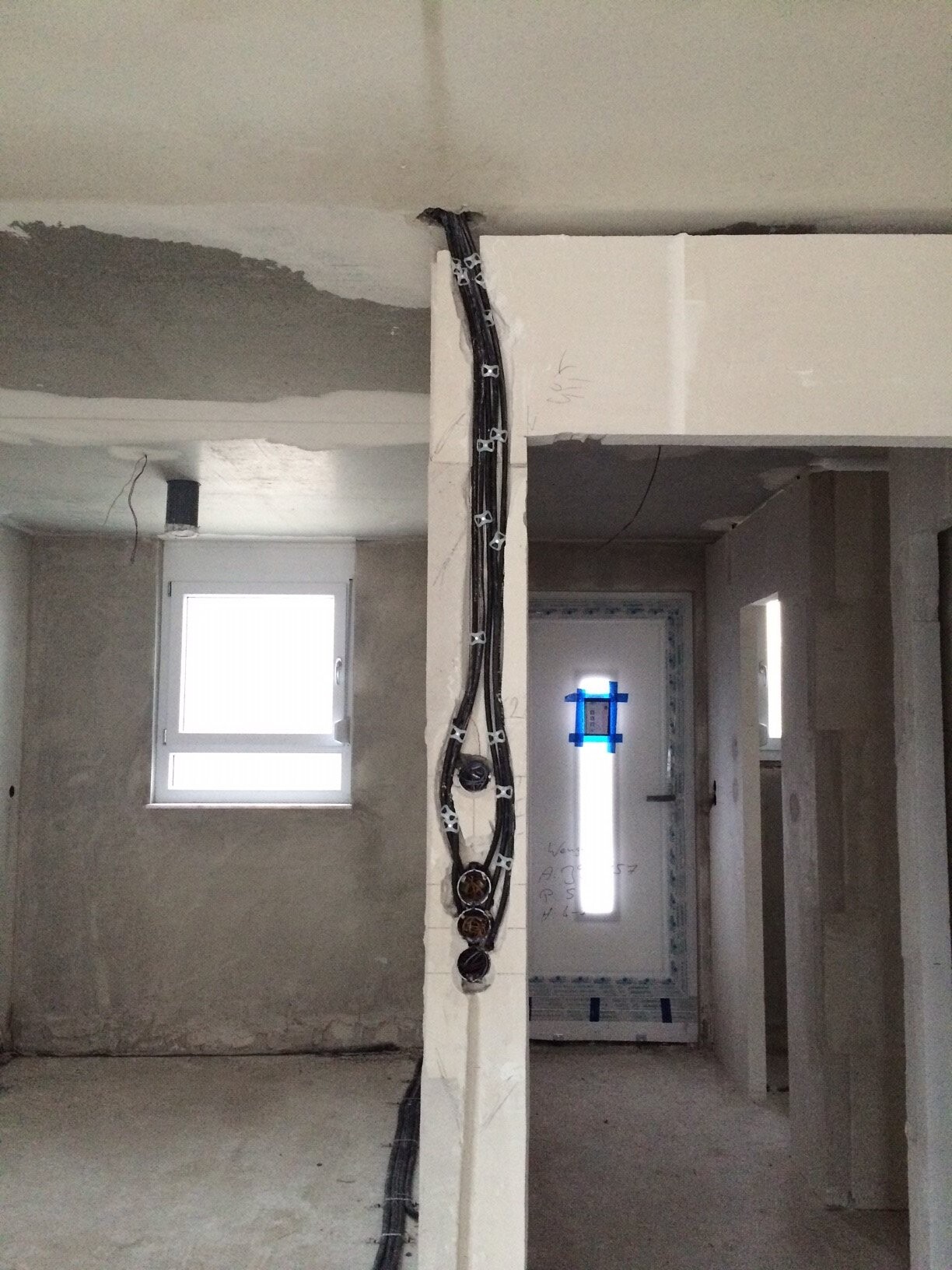 Unfertiger Wohnungsbau: Kabelstrang an Säule, Tür mit blauem Klebeband, Fenster