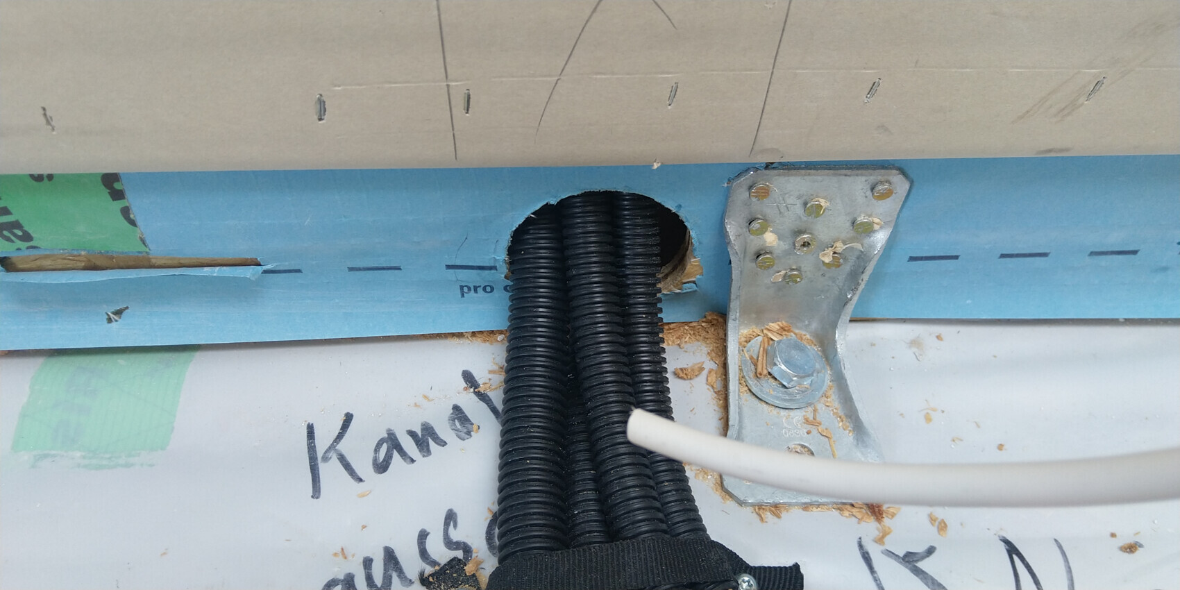 Offene elektrische Installation mit schwarzen Schutzleitungen im Rohbau